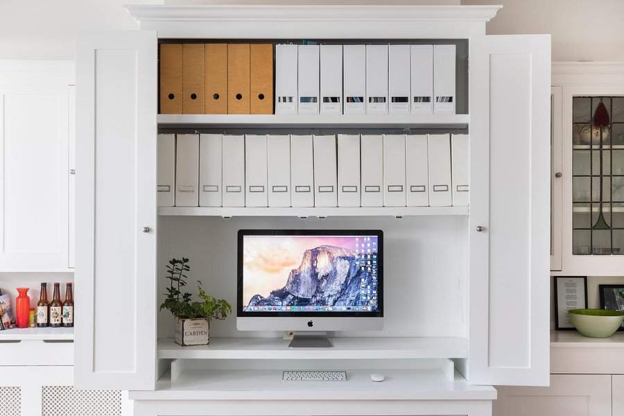 Neat white cabinet office with organized shelves and iMac