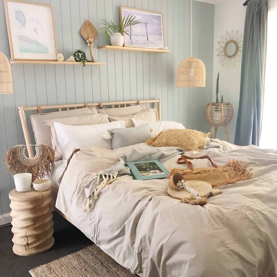 Cozy bedroom with a boho aesthetic, featuring a bed with white linens, wooden furniture, woven decor, and pastel green accent wall