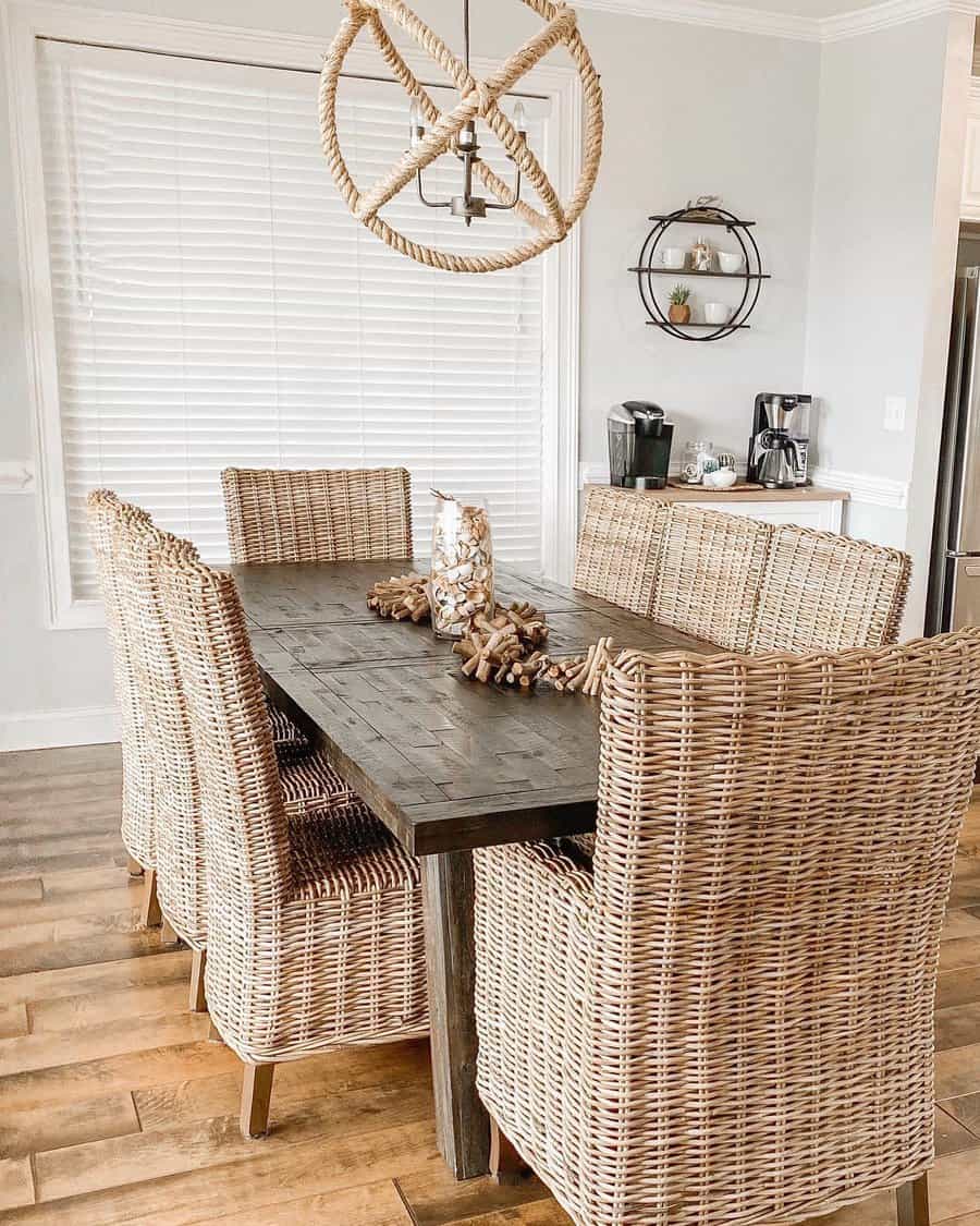 Dining area with wicker chairs, a dark wooden table, and a rope chandelier