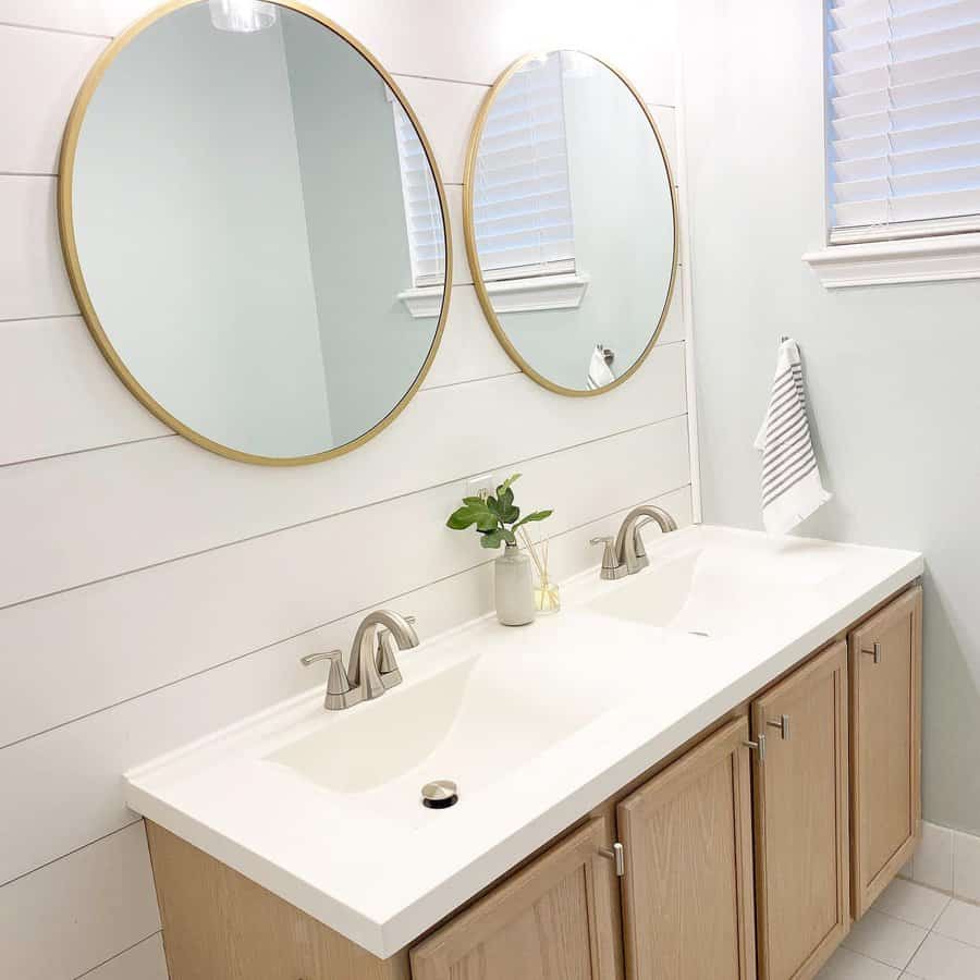 Double vanity with round mirrors in a coastal farmhouse bathroom