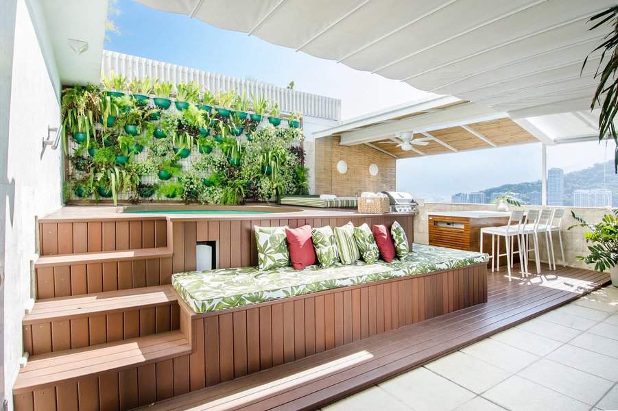 Rooftop garden patio with bench and city view