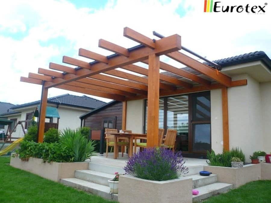 Wooden pergola over patio with dining set and plants