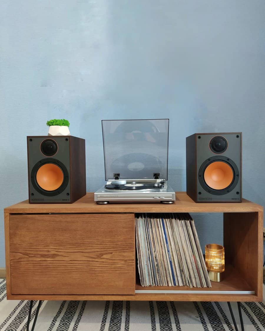 Wooden console table with vinyl storage, a turntable, and speakers, creating a stylish and functional music setup