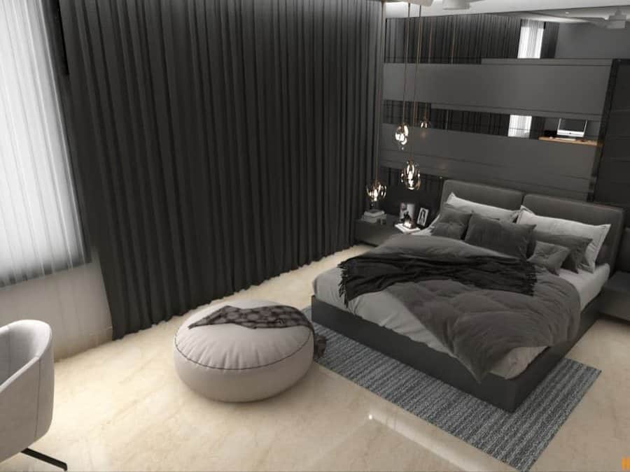 Sleek black bedroom with layered bedding, mirrored wall panels, pendant lights, and a cozy pouf on a neutral marble floor