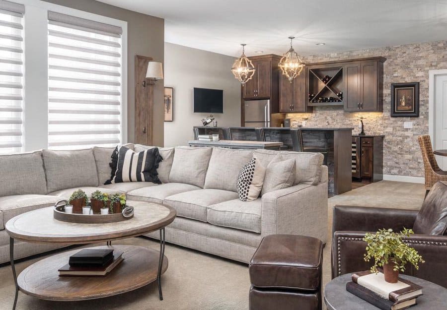 Stylish basement with an open-concept lounge and bar, featuring warm wood tones, modern lighting, and a cozy sectional for entertaining.