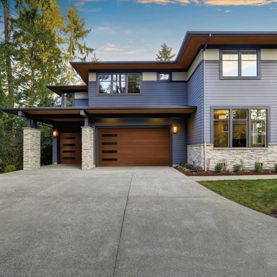 Modern house with wooden garage door and stone pillars