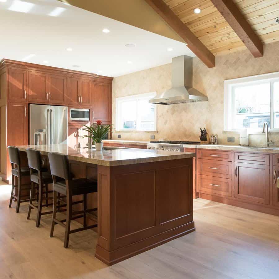 Modern kitchen with wooden cabinets, island, and stainless steel appliances.