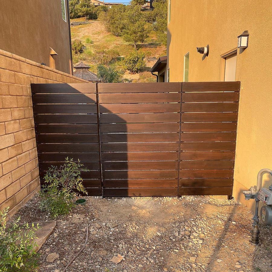 Deeply tinted horizontal fence beside a house