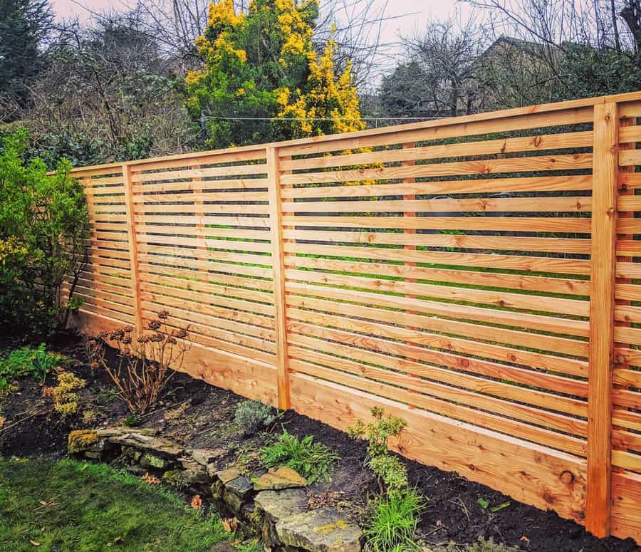 Cedar fence with slatted design in a lush garden