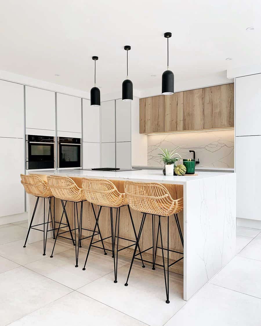 Minimalist kitchen with wicker stools and black pendants