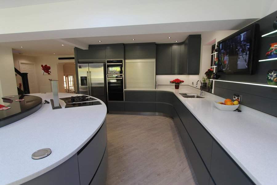 Modern kitchen with sleek grey cabinets, white countertops, and stainless steel appliances