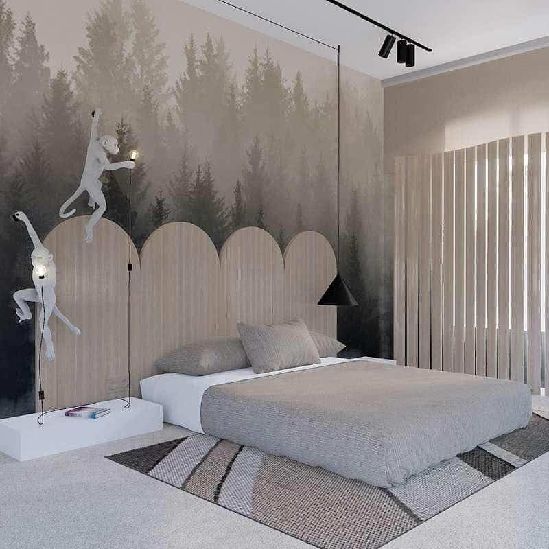 Bedroom with forest mural, minimalist bed, geometric rug, and monkey-shaped light fixtures on wall; neutral tones and modern decor