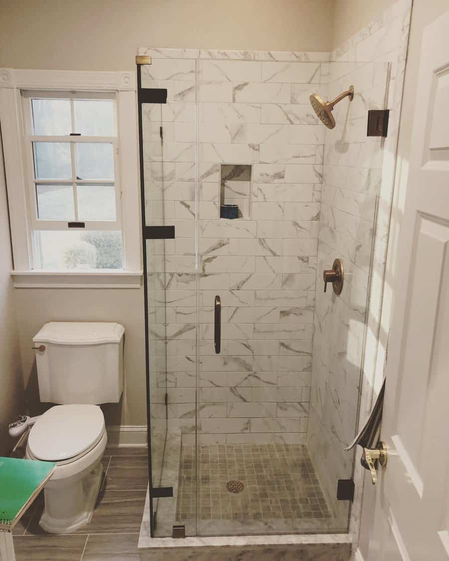 marble bathroom shower with gold fixtures 