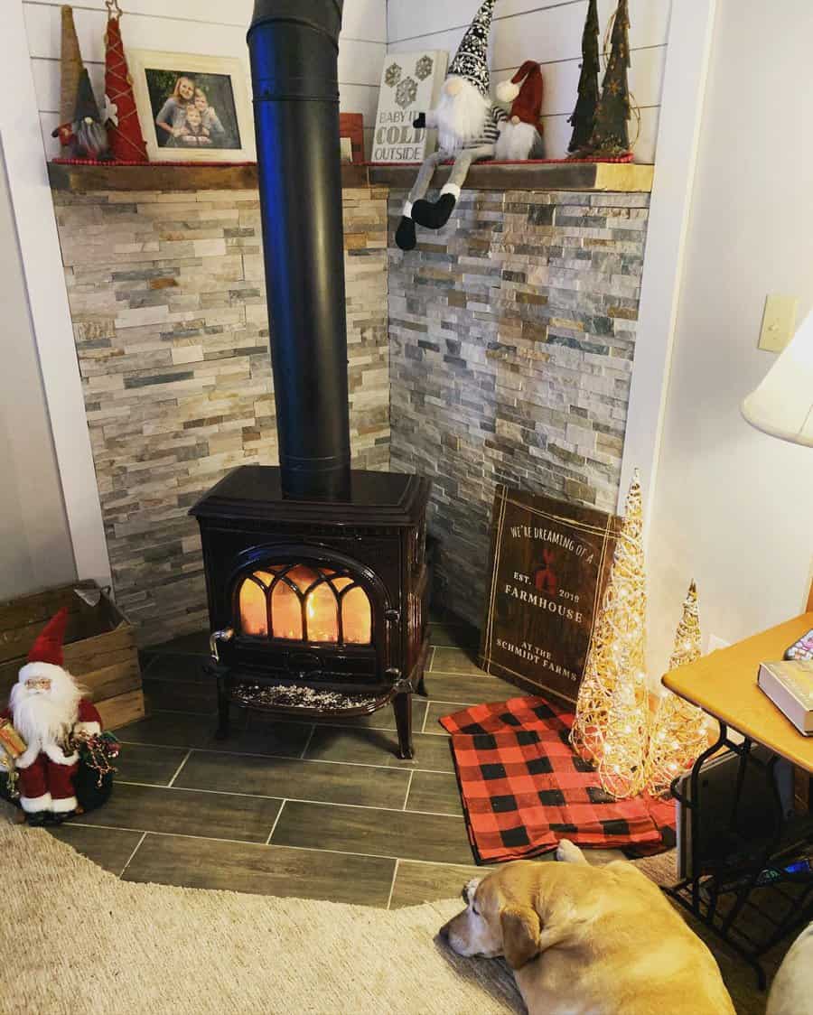 Festive corner wood stove with a stone-accented hearth, Christmas decor, and a cozy dog resting nearby for a warm holiday ambiance.