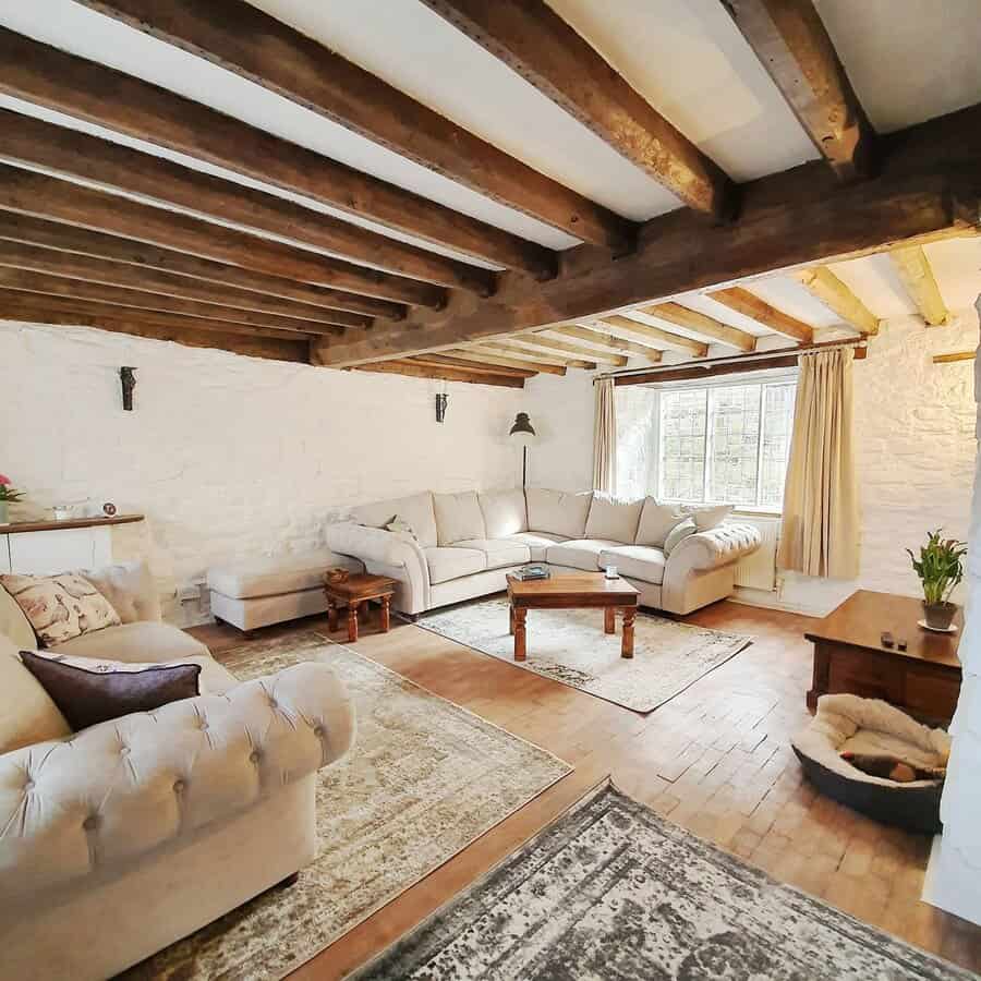 Rustic living room with white walls and wooden beams