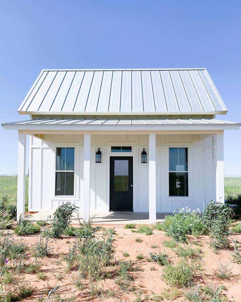 Small white house with a metal roof on a dry landscape