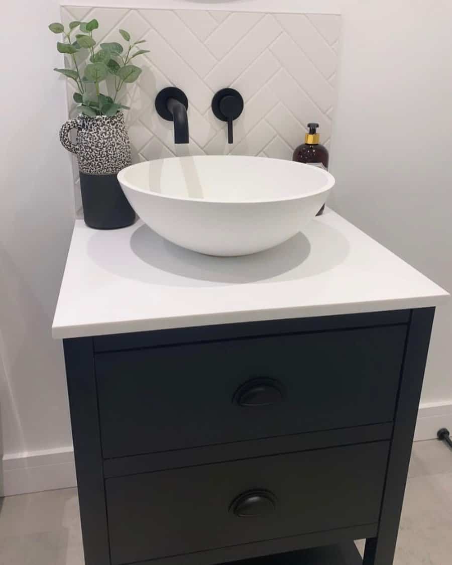 bathroom sink with herringbone tile backsplash