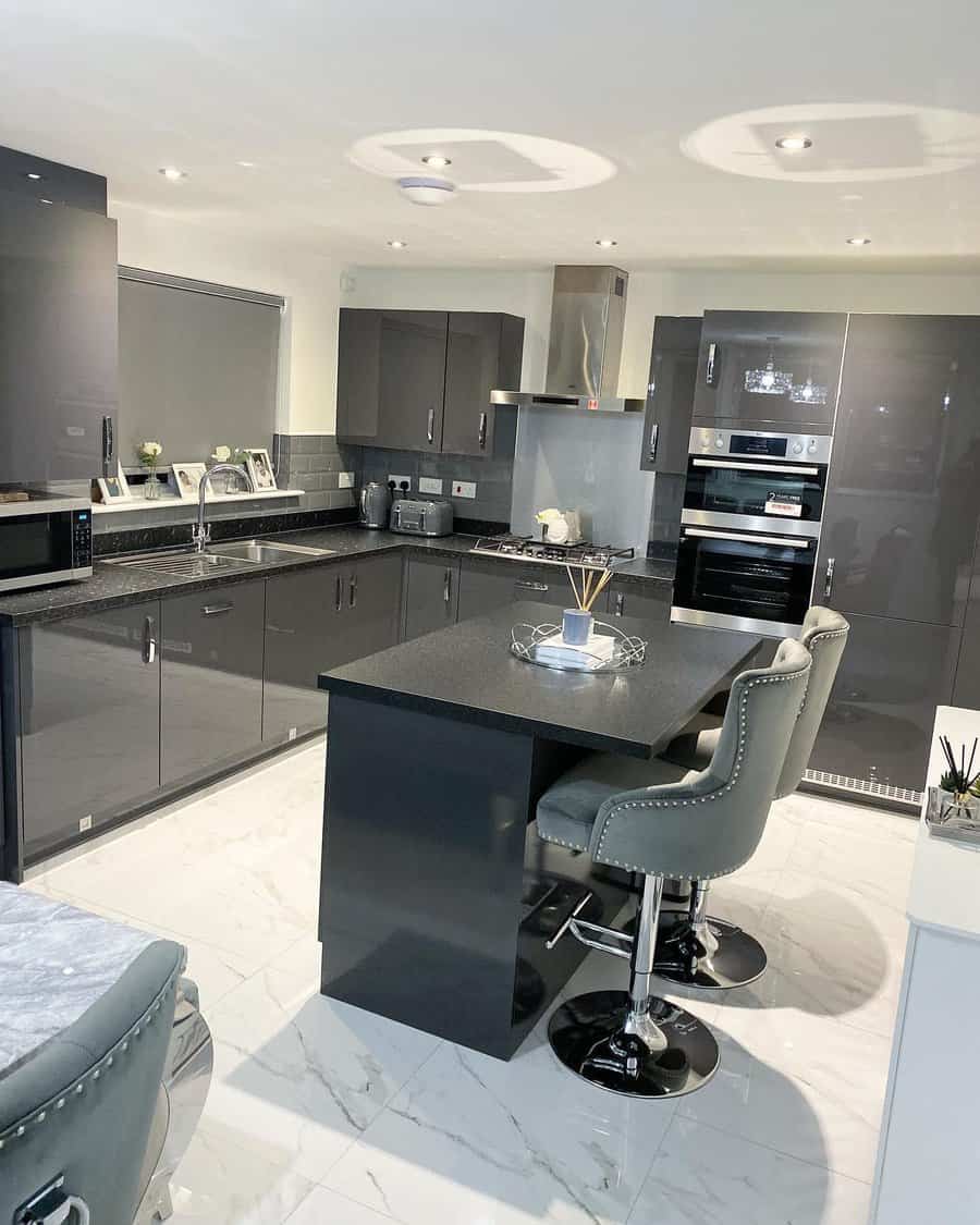 Modern kitchen with gray cabinets, island seating, and stainless steel appliances