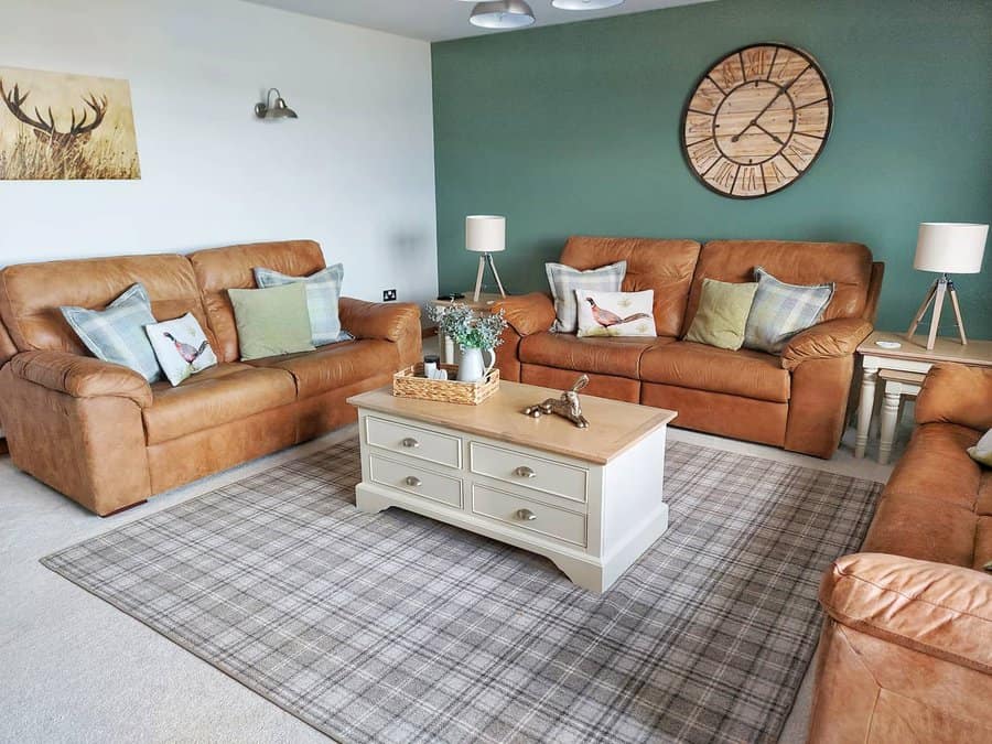 Modern country living room with tan leather sofas and teal wall