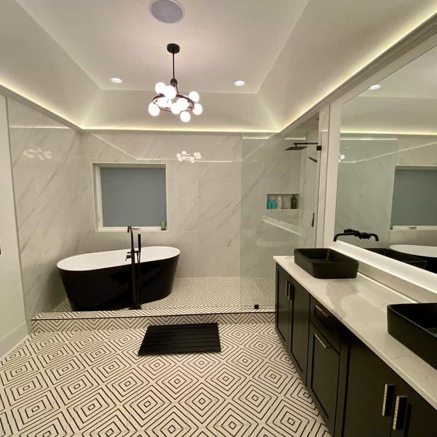 Modern bathroom with a tray ceiling, cove lighting, bold black and white accents, and geometric flooring, creating a sleek and stylish space.