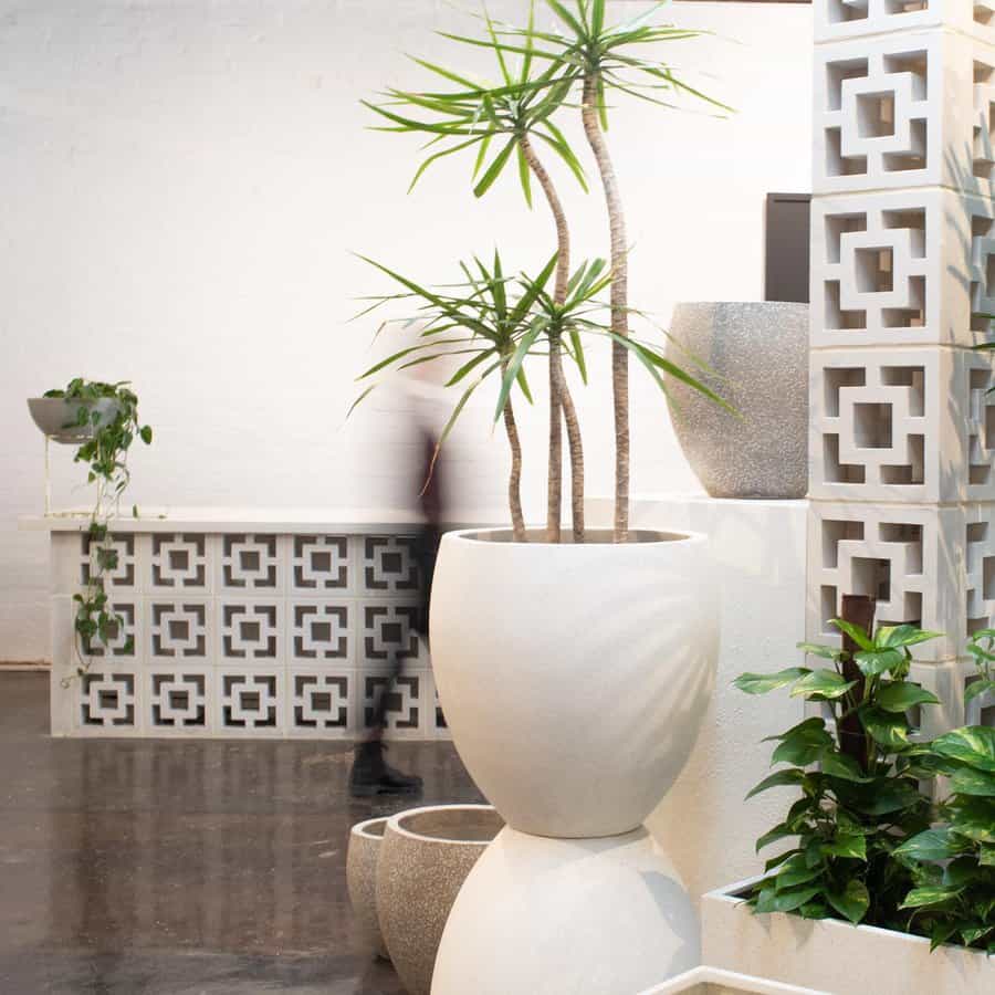 Modern interior with decorative cinder block partitions, geometric patterns, and stylish planters, creating a sleek, minimalist design with natural elements