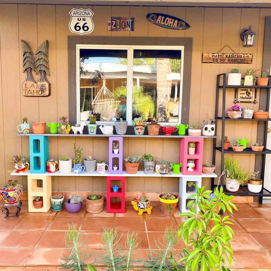 Vibrant DIY plant shelf made from colorful cinder blocks and wooden planks, showcasing a variety of succulents and decorative pots on a patio