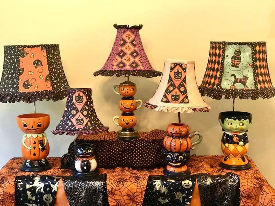 A collection of Halloween-themed lamps with pumpkin and cat designs set on a table