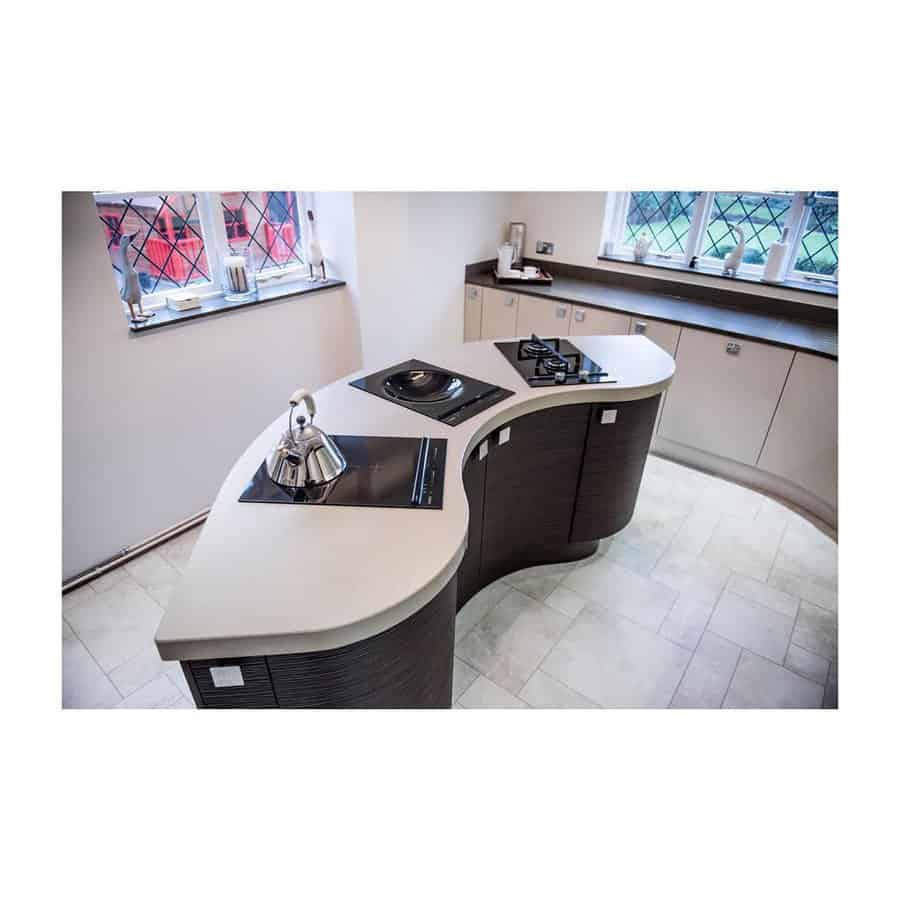 Curved kitchen counter with modern appliances and stained glass window