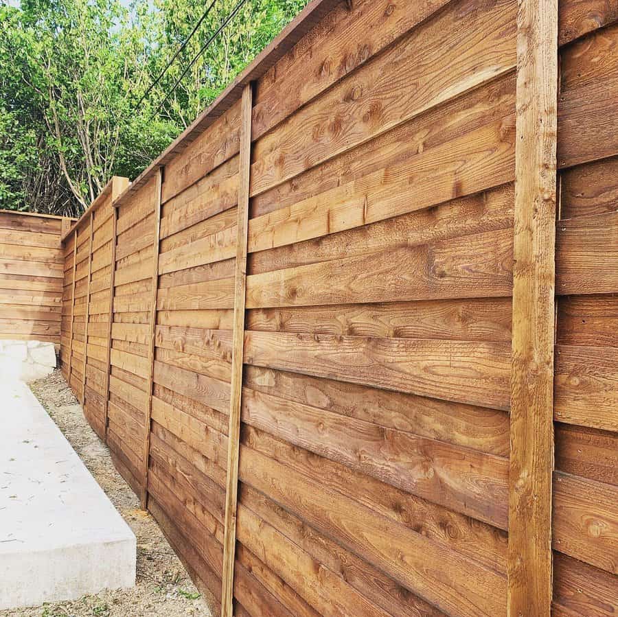 Warm toned wooden horizontal fence with supportive posts