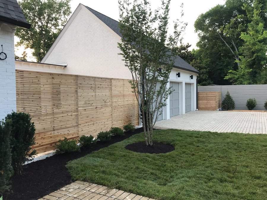 Landscaped yard with horizontal privacy fence and tree