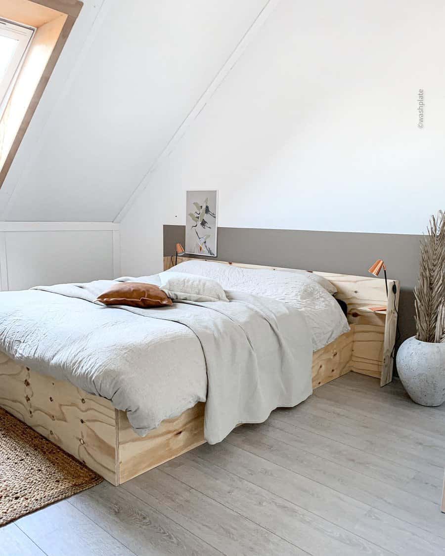 Minimalist attic bedroom with a custom plywood bed frame, soft neutral bedding, and natural accents. Skylight and warm textures create a cozy feel.