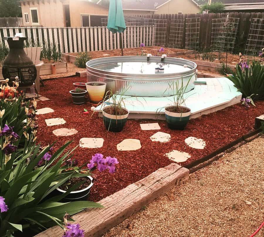 backyard landscape with stock tank pool