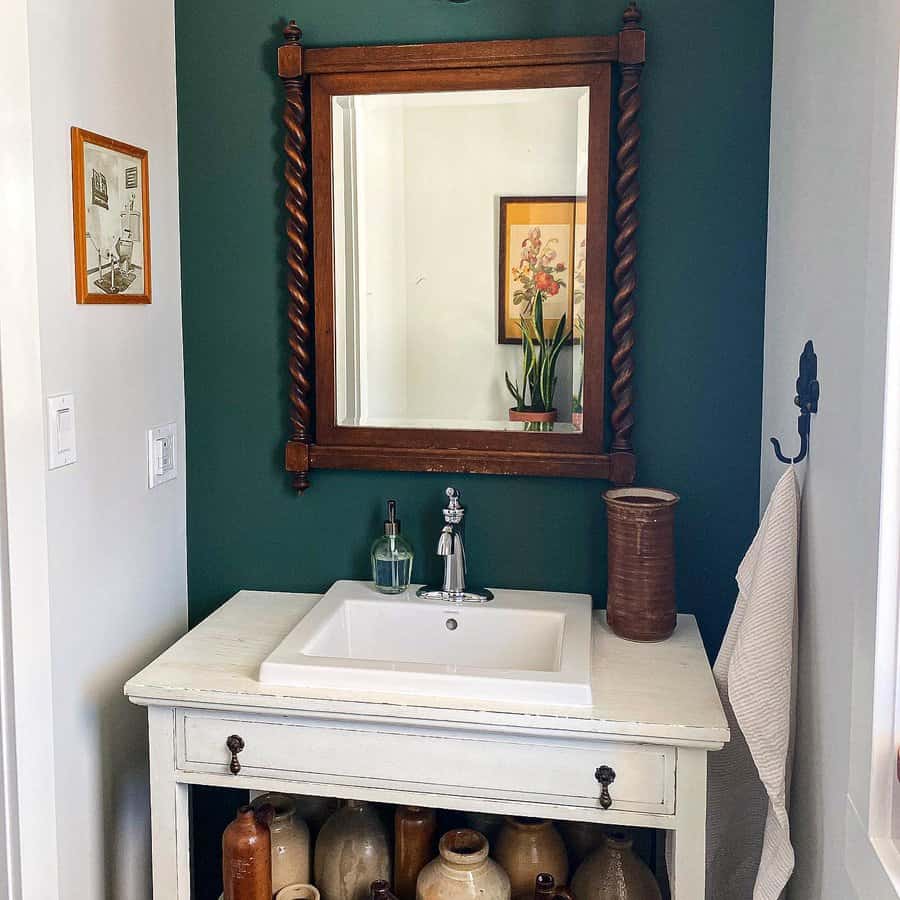 Vintage vanity in bathroom with dark green wall