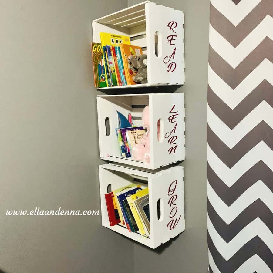 Wall-mounted white wooden crates labeled "Read," "Learn," and "Grow," used as book storage for children's books and toys.