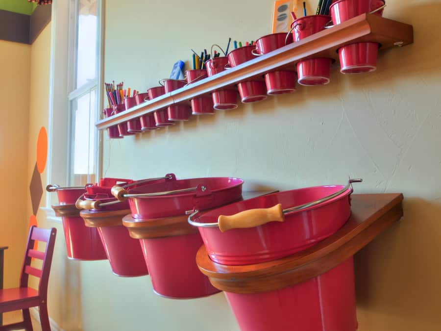 Red buckets on shelves for art supply storage