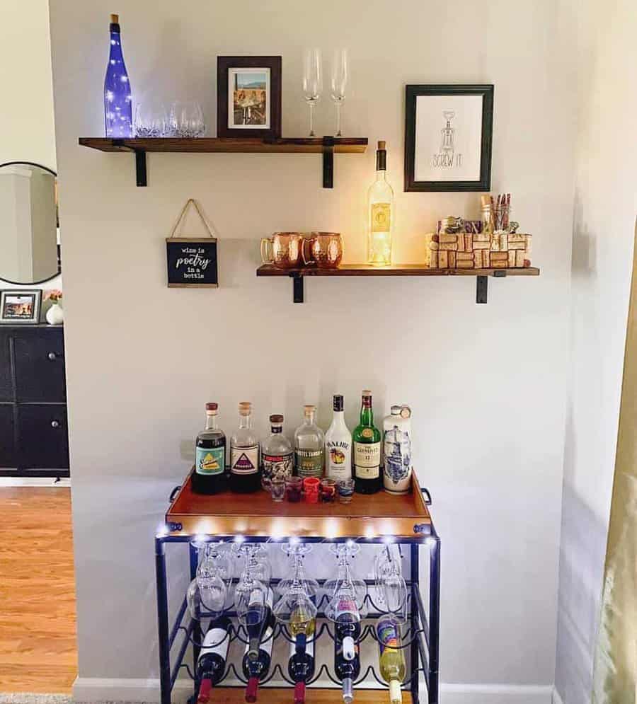 Stylish home bar setup with floating shelves displaying liquor bottles, glasses, and decor above a wine rack and counter with more bottles