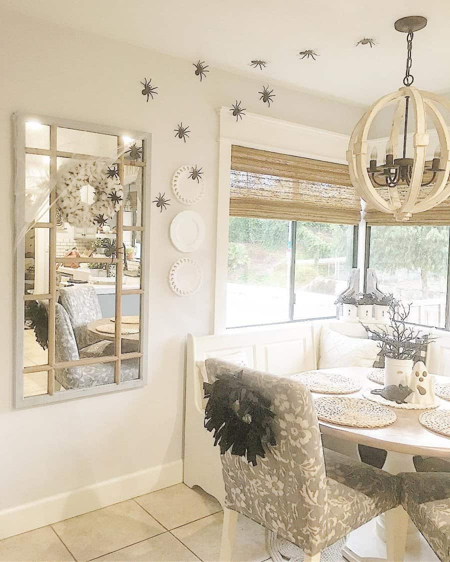 Dining nook decorated for Halloween with spider decals on wall and spider webs on chairs