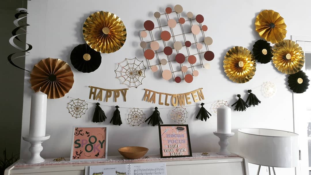 Halloween decorations with gold fans, spider webs, and a "Happy Halloween" banner