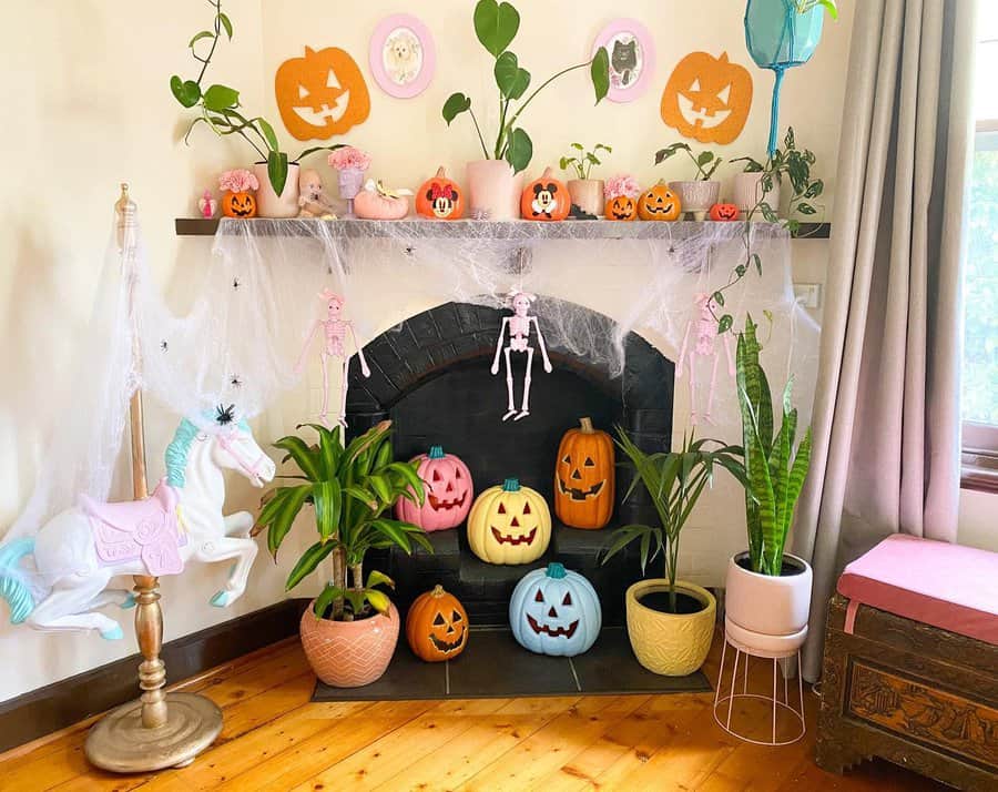 Halloween-themed fireplace with pumpkins, plants, and pastel-colored decorations