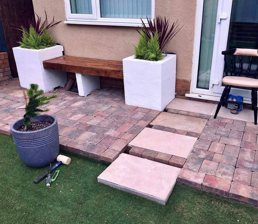 Brick patio with bench and potted plants