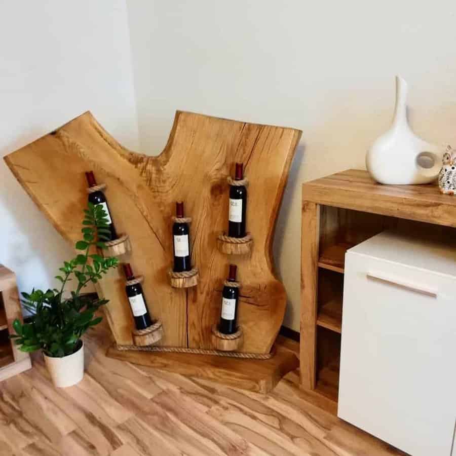 Rustic wooden wine rack crafted from a tree slab, featuring rope-accented bottle holders for a unique and natural display