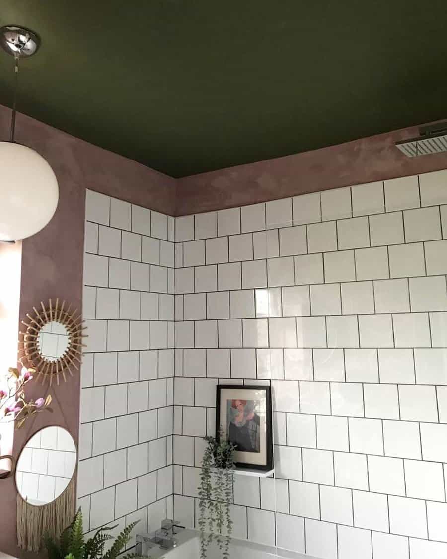 Modern bathroom with a deep green ceiling, white subway tiles, and soft pink walls, creating a stylish contrast with boho-inspired decor elements.