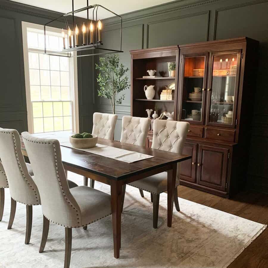 Elegant dining room with a dark wood table, beige upholstered chairs, a wooden hutch, and a modern chandelier on a light rug