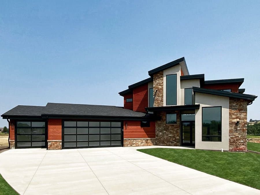 Modern red and stone house with black garage door