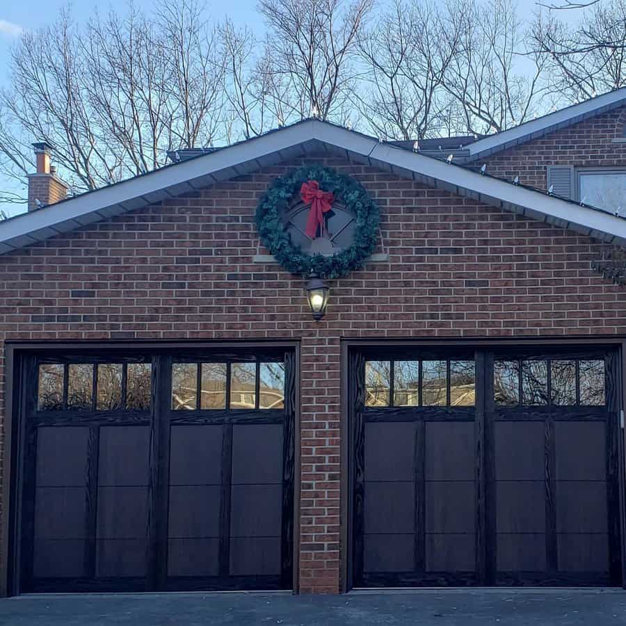 Brick house with dark garage doors and Christmas wreath