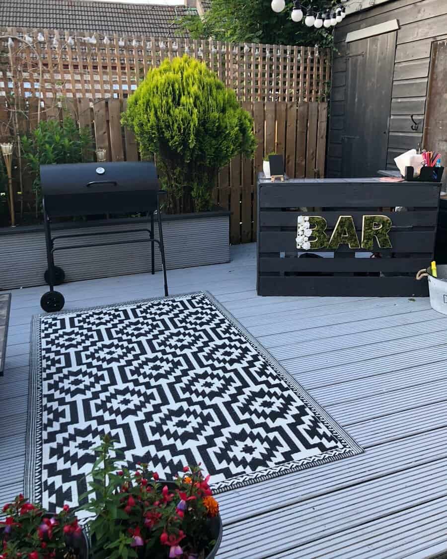 Stylish outdoor bar area with patterned rug and grill