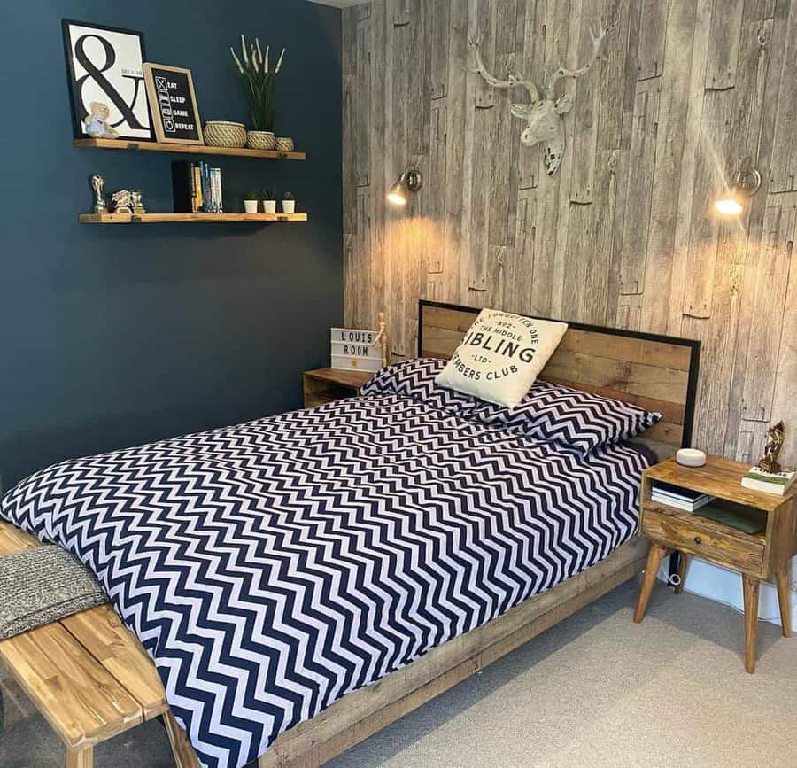 Rustic bedroom with wooden floating shelves, a dark accent wall, and a cozy bed featuring a bold chevron-patterned duvet