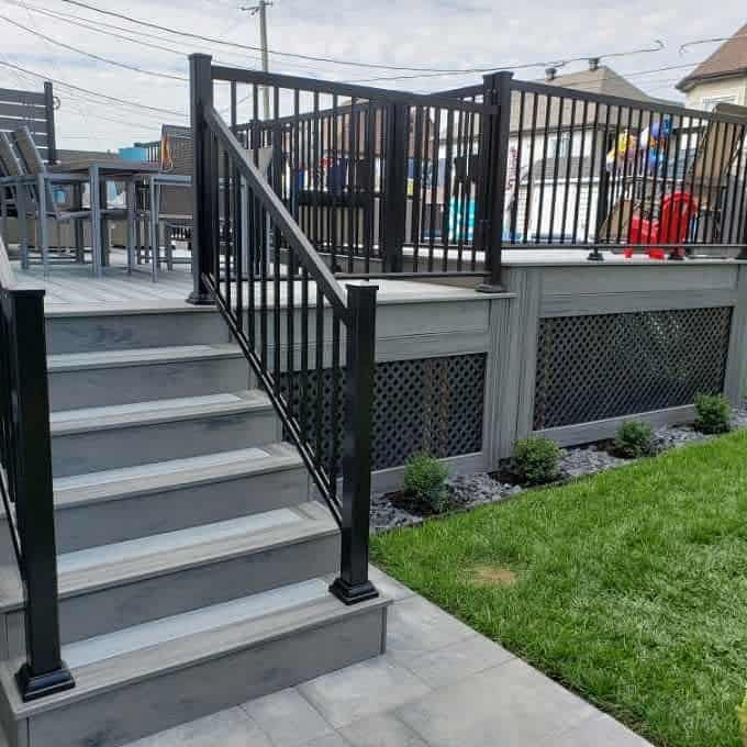 Gray deck with decorative skirting and black railing