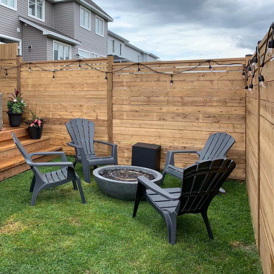 Cozy backyard corner with wooden fence and patio chairs