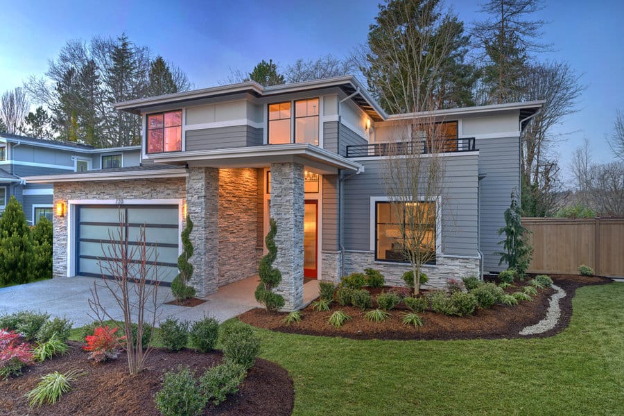 Modern house with landscaped front yard at dusk